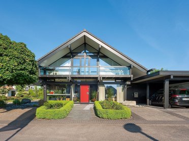 Futuristisches Haus mit Glasfront und roten Akzenten