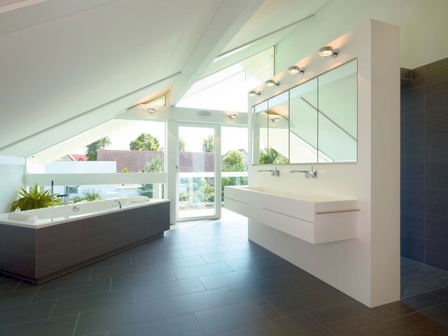 Helles Badezimmer mit Badewanne und großer Fensterfront im HUF HAUS ART 4