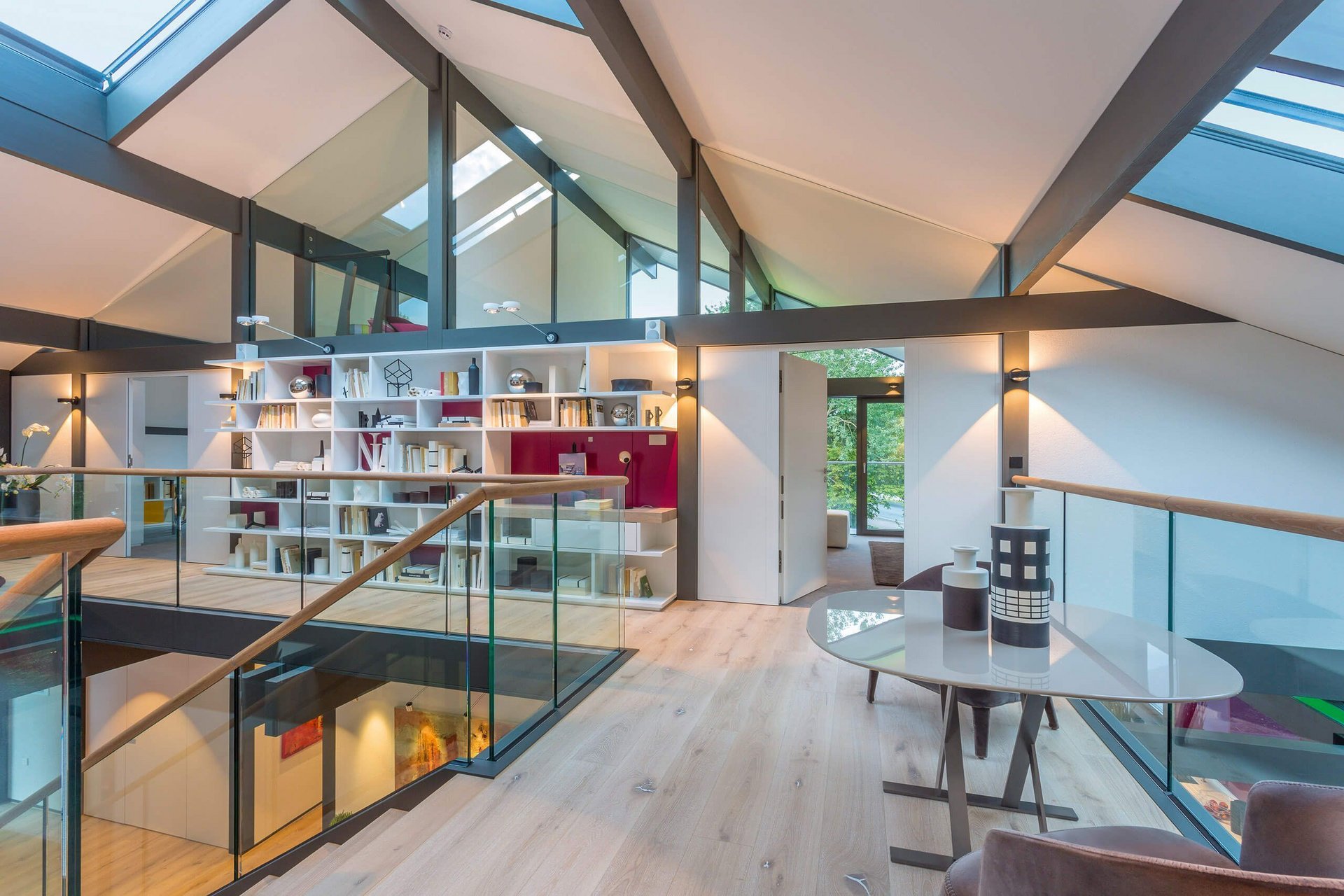 Helles und modernes Loft mit Holzfußboden und Glasgeländer