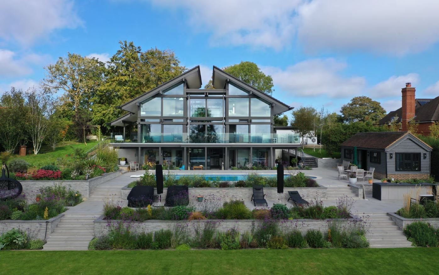 Elegante Architektur eines Hauses mit Glasfronten und Gartenlandschaft
