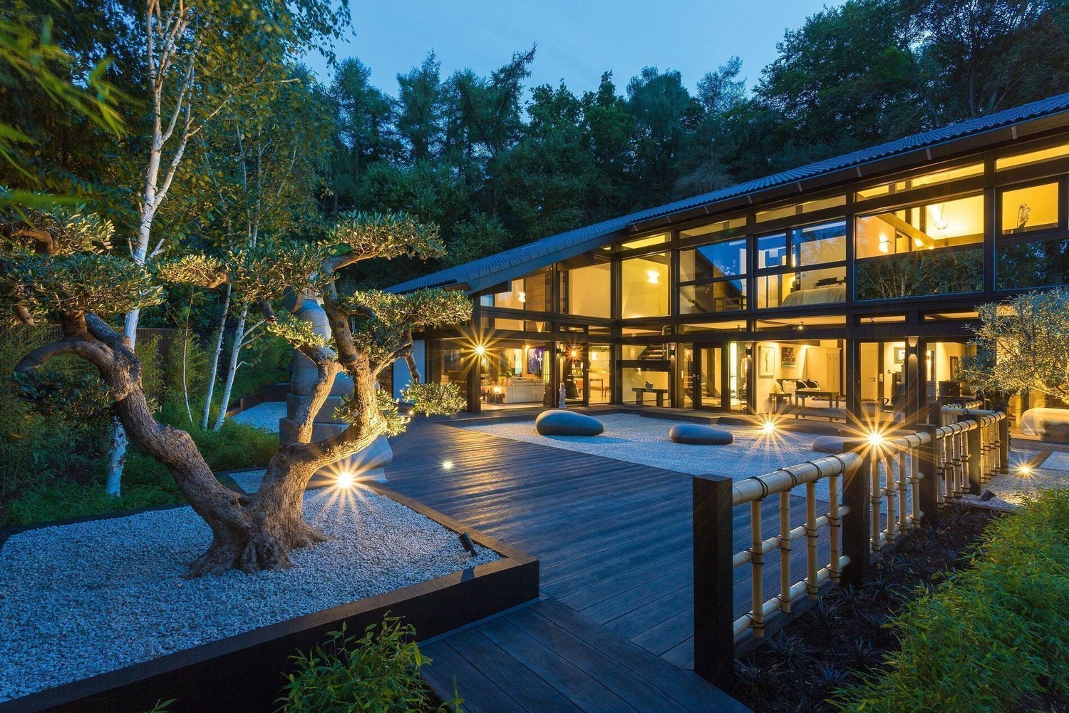 Moderne Architektur eines HUF Hauses mit Pool Ein HUF Haus mit Glasfassade, Garten und eleganten Außenpool bei Nacht.