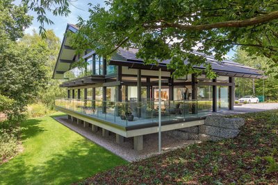 Futuristisches Gebäude mit flacher Dachkonstruktion und begrüntem Garten