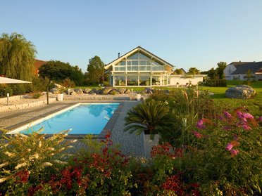 Modernes HUF HAUS ART 4 mit Pool und Gartenlandschaft