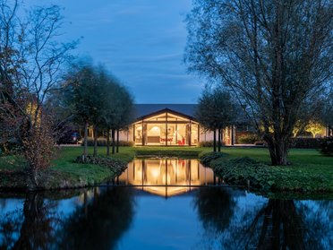 Bungalow mit organischen Formen, großen Glasflächen und schöner Umgebung