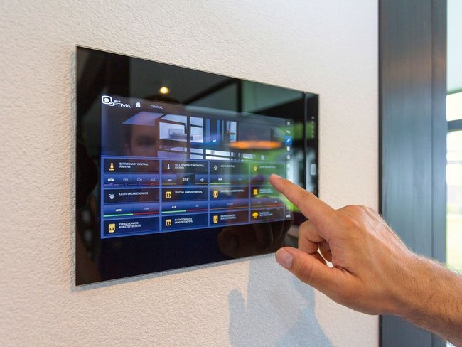 Moderne Steuerungstechnik in einem Familienhaus Hand bedient einem digitalen Steuerungspanel in einem stilvollen Architektenhaus