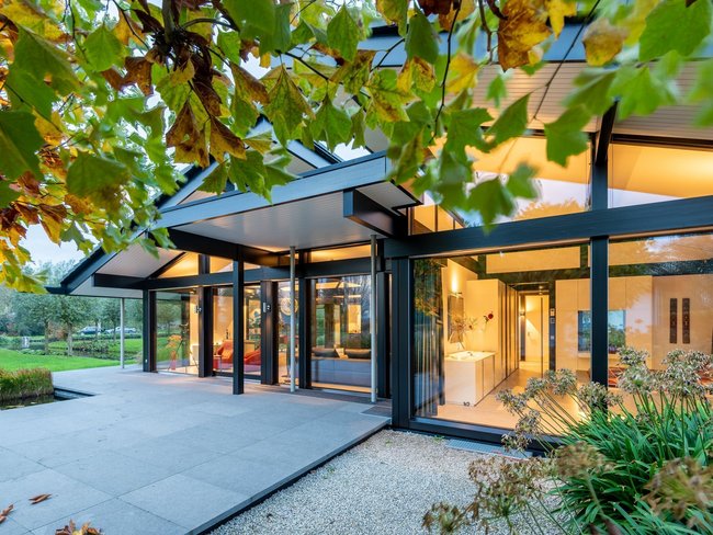 Moderner Bungalow in traumhafter Landschaft mit Bäumen und Wiesen