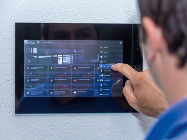 Moderne Haussteuerung mit Touchscreen-Display Benutzer steuert smarte Funktionen eines Familienhauses über ein Touchscreen-Panel