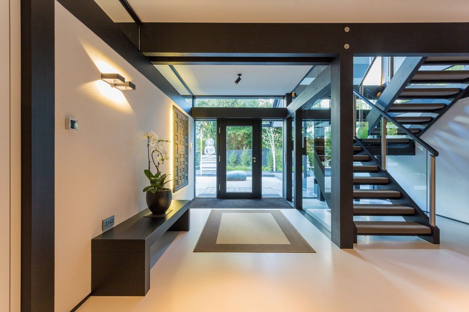 Modernes HUF Haus mit eleganter Architektur und Garten Offener Eingangsbereich eines modernen Hauses mit Glasfassade und Treppe