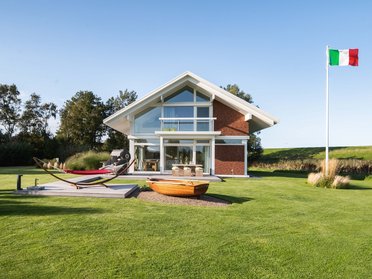 Gemütliches Architektenhaus mit stilvollem Design Modernes Familienhaus in einer grünen Umgebung mit italienischer Flagge