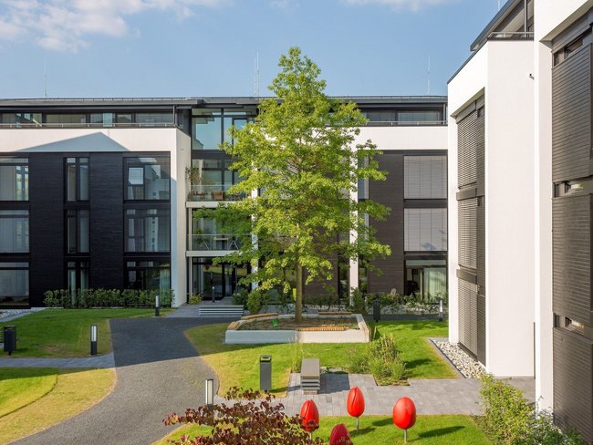 HUF Bürogebäude im modernen Architekturstil Ansicht eines Bürogebäudes mit Garten und modernen Designelementen