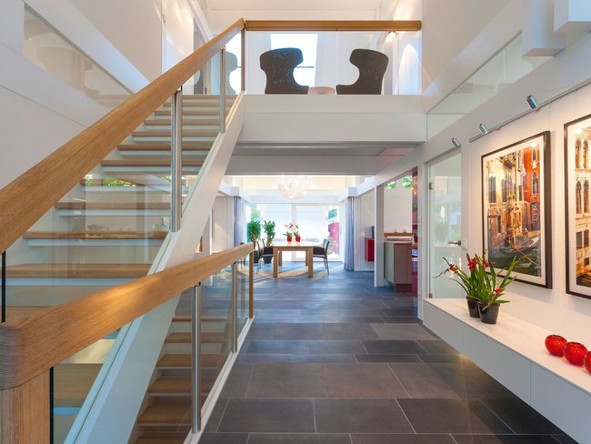 HUF Musterhaus Frankfurt weiss 36 Geräumiger Flur mit Treppe, Bildern und Pflanzen in hellen Farben