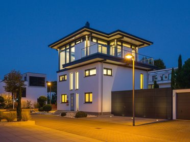 Modernisiertes Bestandshaus mit HUF Aufstockung bei Nacht Elegantes Haus mit Aufstockung, beleuchtet, moderne Architektur
