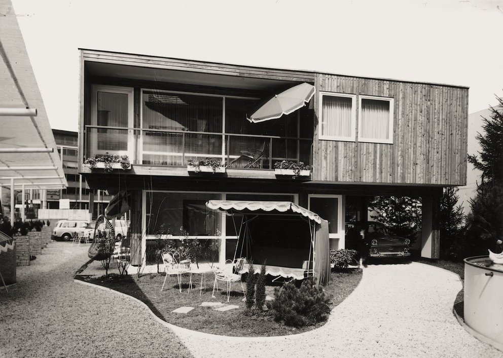Moderne Architektur eines Hauses mit Garten Zweistöckiges Gebäude mit Holzverkleidung und Gartenmöbeln