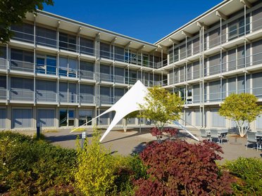 HUF Bürogebäude mit modernen architektonischen Elementen Ansicht des Bürogebäudes HUF mit Sonnensegel und Grünflächen