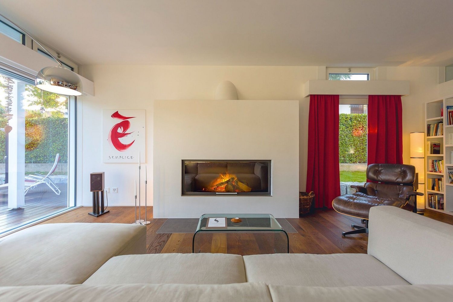 Modernes Wohnzimmer mit klarer Architektur und Eleganz Helles Wohnzimmer mit Kamin, rotem Vorhang und moderner Einrichtung