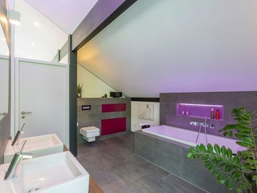 Modernes Badezimmer in einem stilvollen Architektenhaus Gemütliches und stilvolles Badezimmer mit Badewanne und modernen Waschbecken