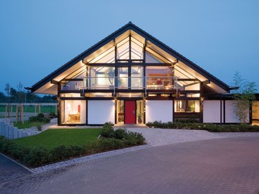 Elegantes Haus mit Glasfront und symmetrischem Dachdesign
